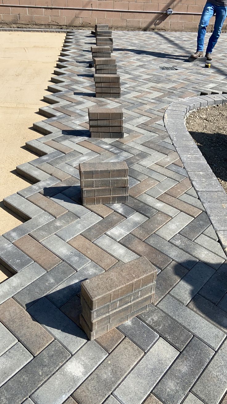 UCB Quadmouth Paver — grey and brown herringbone rectangular interlocking concrete pavers being installed on a driveway by Unique Concrete Builders Kenya