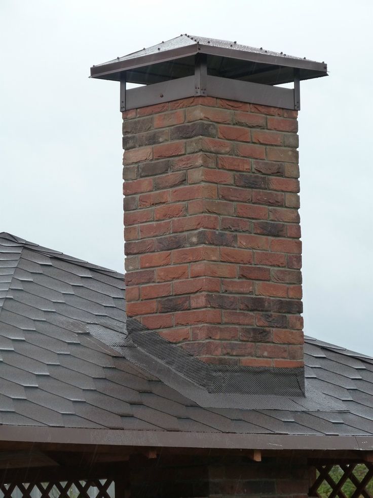 brick chimney with metal chimney cap cover on grey slate roof by Unique Concrete Builders Kenya