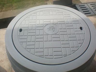 round grey precast concrete manhole cover with grid pattern by Unique Concrete Builders Kenya