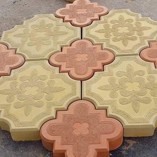 UCB Flower Paver — yellow and red flower-patterned decorative concrete paver tiles arranged in a colourful display by Unique Concrete Builders Kenya