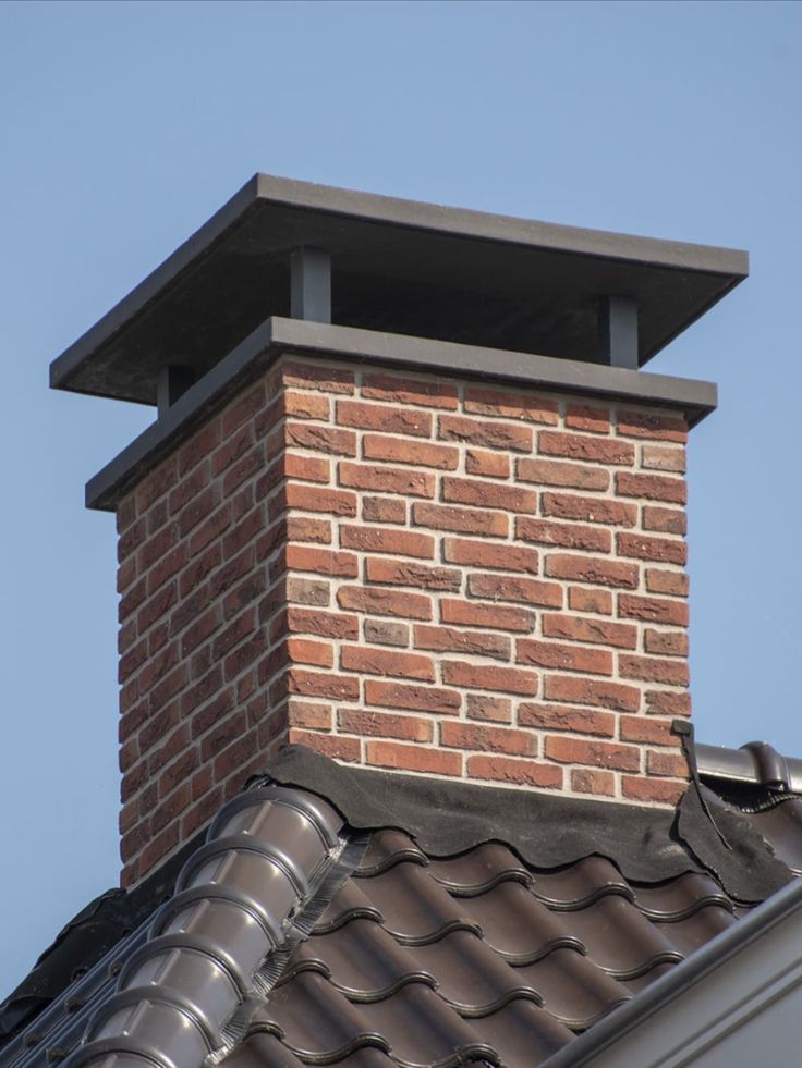 brick chimney with flat concrete cover on rooftop against blue sky by Unique Concrete Builders Kenya