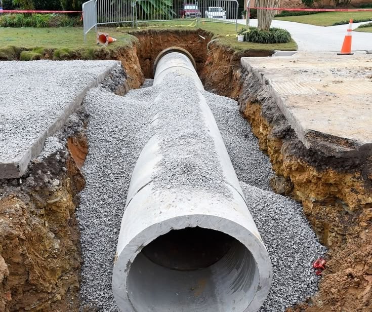 UCB 450mm Concrete Culvert — precast concrete culvert pipe being lowered into a trench at a road construction site by Unique Concrete Builders Kenya