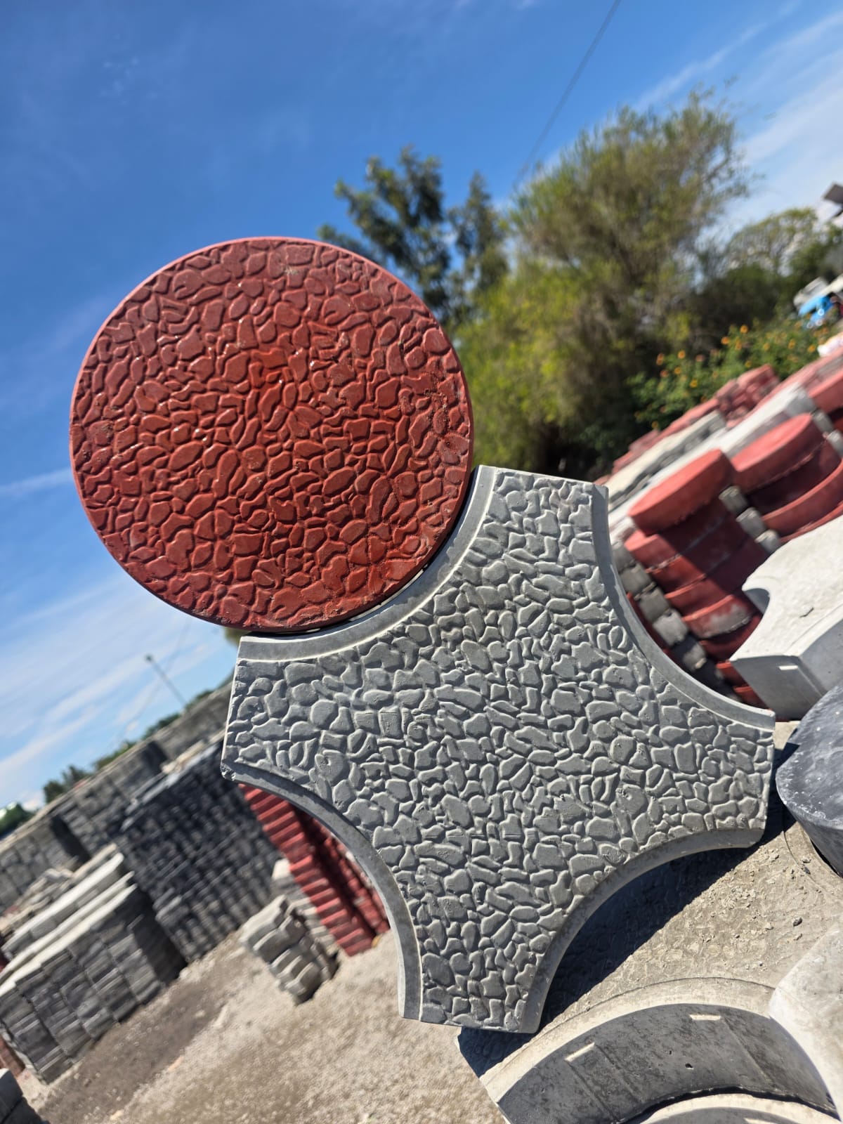 Red round paver paired with grey cross-shaped paver from Unique Concrete Builders Kenya