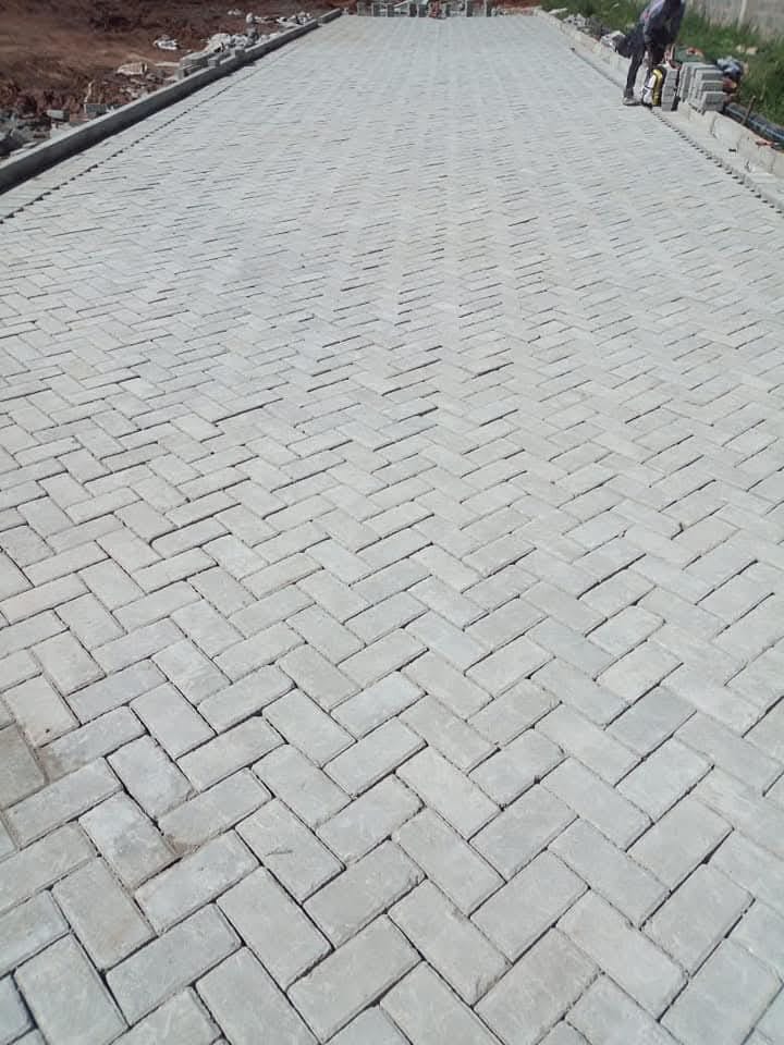Close-up of herringbone cabro paving with concrete road kerbs on both sides in Kenya — UCB interlocking paving blocks and road edging by Unique Concrete Builders