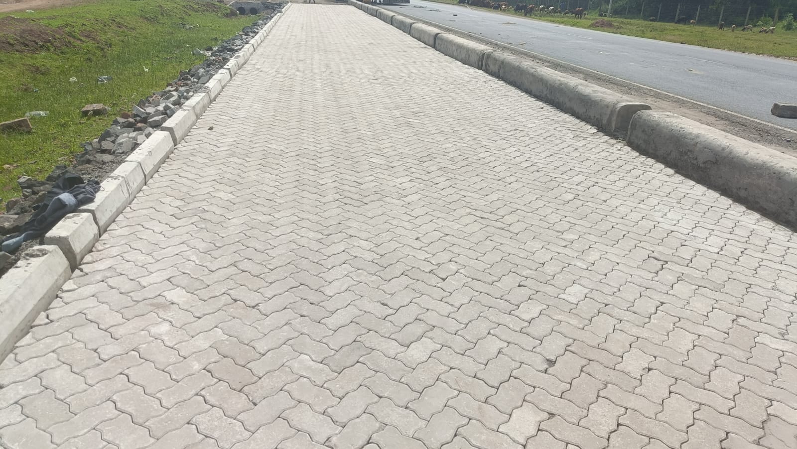 Highway road paved with Uni Pavers in Kenya featuring white concrete road kerbs on both sides — UCB interlocking paving blocks on a major road with kerb edging by Unique Concrete Builders