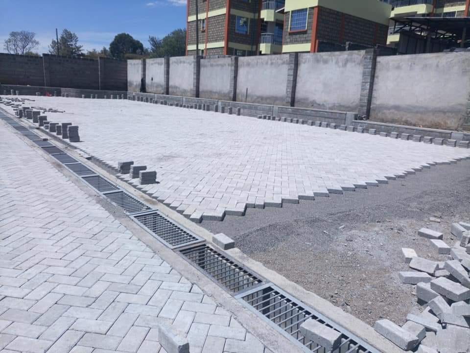 Unique Concrete Builders Channels with grated cover integrated into interlocking paving by Unique Concrete Builders