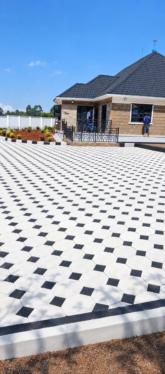 UCB Octagon Pavers installed on a premium residential driveway — white octagon pavers with black square inserts beside a modern clay-tile roof house in Kenya by Unique Concrete Builders