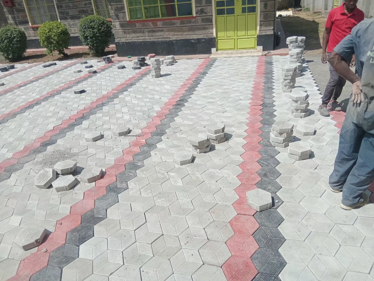 UCB Hexagon Paver installation — red, grey and black hexagonal interlocking concrete paving blocks installed at a real UCB project site in Kenya by Unique Concrete Builders